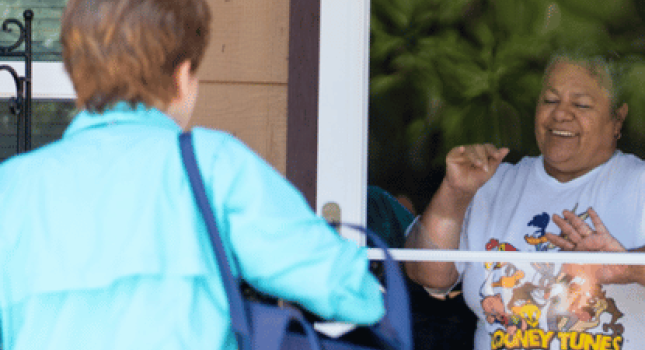 a neighbor about to receive a meal from a volunteer