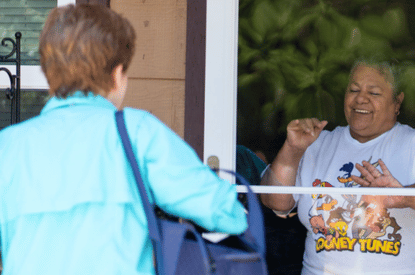 a neighbor about to receive a meal from a volunteer